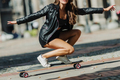 Beautiful young skater woman riding on her longboard in the city. Stylish girl in street clothes - PhotoDune Item for Sale
