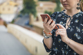 Cropped view of Pretty young woman in a black dress using smartphone at old town street. Travel by - PhotoDune Item for Sale