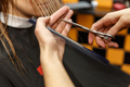 Professional hairdresser dyeing hair of her client in salon. Haircutter cuting hair. Selective focus - PhotoDune Item for Sale