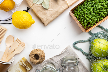 set. Brushes, soap, textile bags, glass jars, wooden cutlery and plant, top view copy space