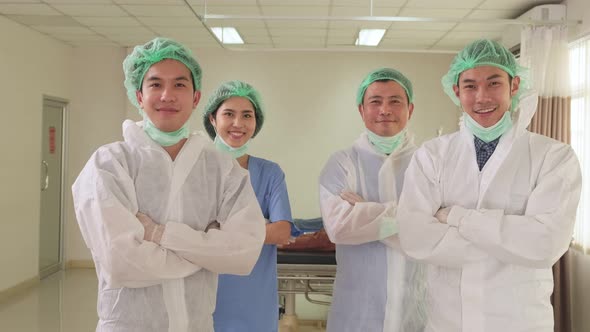 Asian group of doctor remove protective surgical face mask after cure covid virus affection patient.