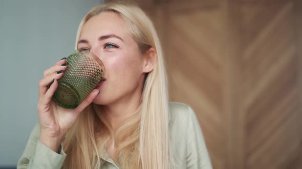 Happy blond woman drinking water