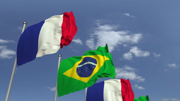 Waving Flags of Brazil and France on Sky Background alt
