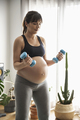 Pregnant woman doing exercises at home - PhotoDune Item for Sale