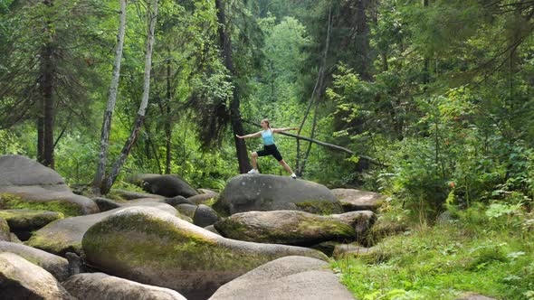 A Girl Does Yoga in the Forest on a Big Stone