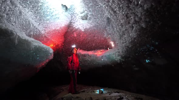 A Guy in an Ice Cave with a Lantern Light