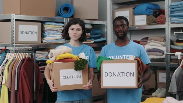 Portrait View of the Diverse Volunteers Holding Cupboard Box with Donation Word and Looking at the