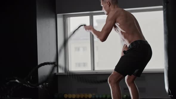 Fit Young Man Working Out By Crossfit Training Program Using Heavy Ropes