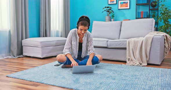 A Woman Writes a Blog Post While Sitting on the Living Room Floor on the