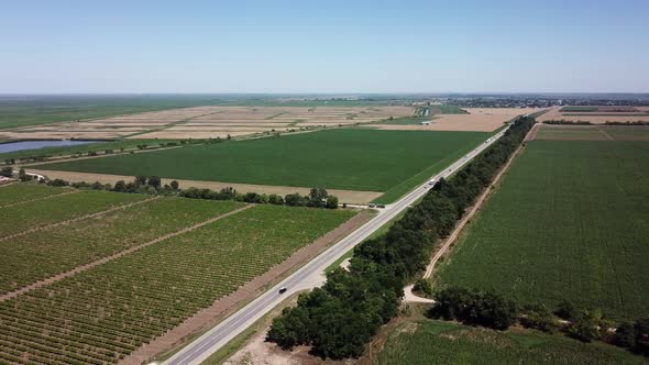 Aerial View of Highway Road Between Meadow and Agricultural Field