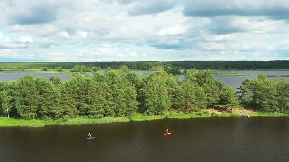 Top View of the Lake Where a Family Swims on Sup Boards at Sunset