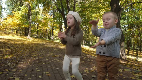 Cute Children Clapping and Singing in Autumn Park