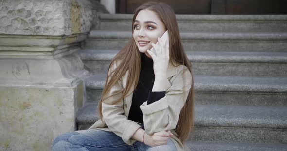 Young Stylish Woman Laughing and Looking Away While Talking Smartphone