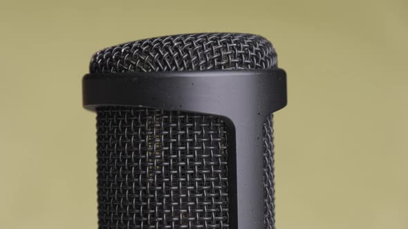 Studio Condenser Microphone Rotates on Yellow Background with Place for Text