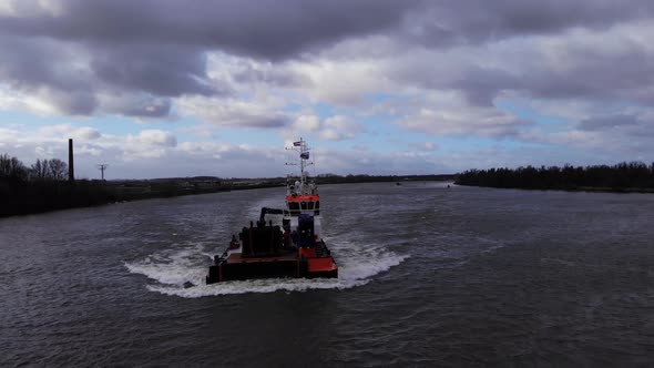 Workboat At Oude Maas River In Puttershoek, Netherlands On A Cloudy Day. wide shot