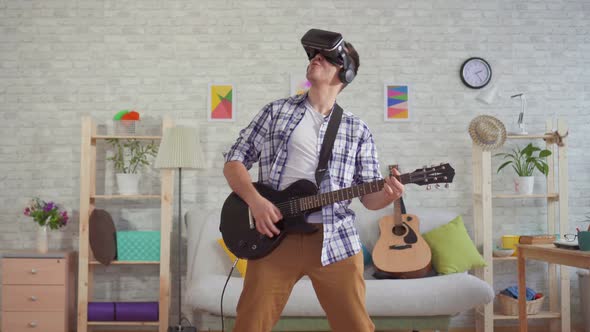 Portrait Young Man Musician in VR Glasses Emotionally Playing the Electric Guitar