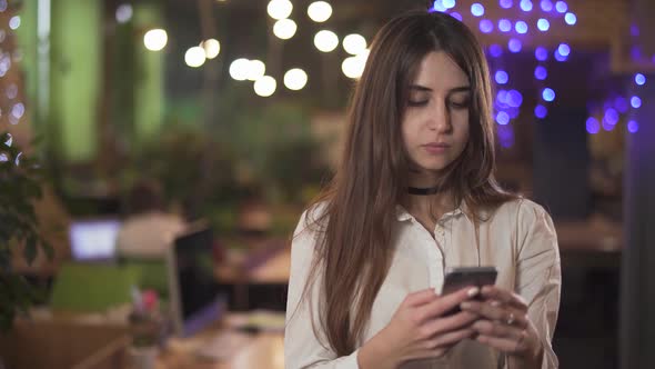 Portrait of Confident Woman in White Blouse Formal Wear Texting Message on Cell Mobile Phone in