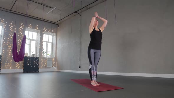 Yoga Indoors  a Plastic Woman Bends and Wraps Around Her Leg