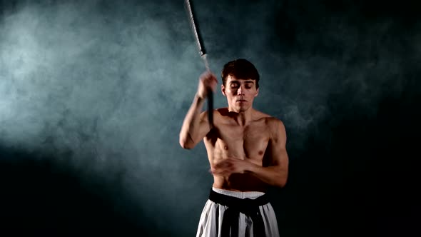 Man Practicing Karate or Kung Fu. Master Holding Nunchuck. Close Up