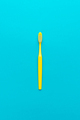 Minimalist Flat Lay Photo of Yellow Toothbrush Over Turquoise Blue Background - PhotoDune Item for Sale
