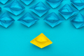 Yellow Paper Ship Stand out Of the Crowd Concept Over Blue Background - PhotoDune Item for Sale