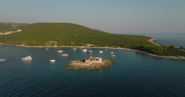 aerial orbit shot of Otocic Gospa island with fortress arza, boats and yachts on background