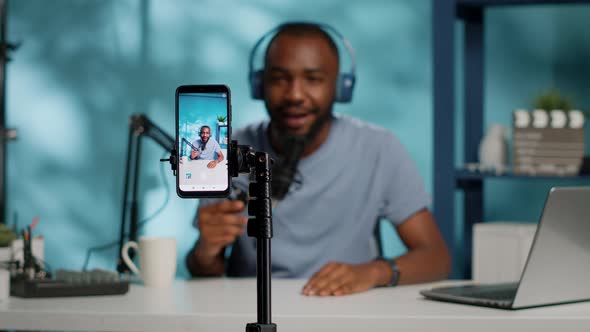 Close Up of Blogger Filming Video with Smartphone on Tripod