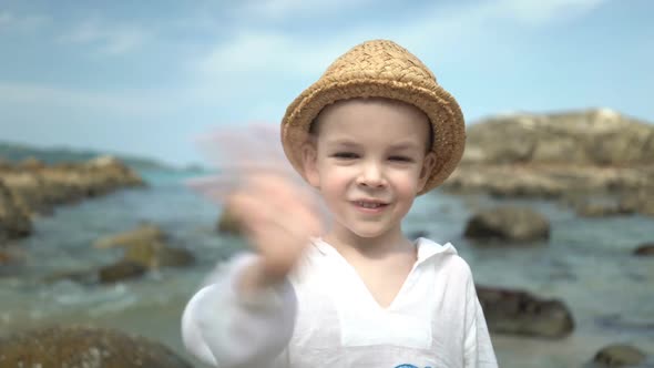 Portrait Cute Boy in a Straw Hat on the Beach
