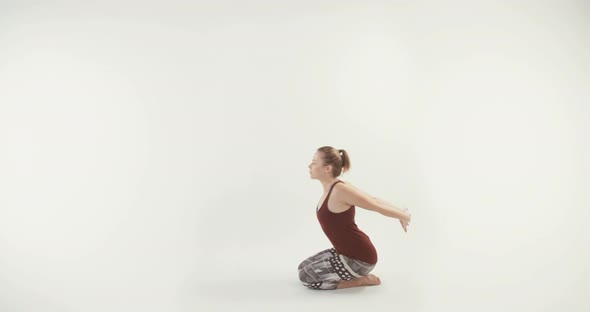 Young attractive woman performing Yoga routine on a white studio background