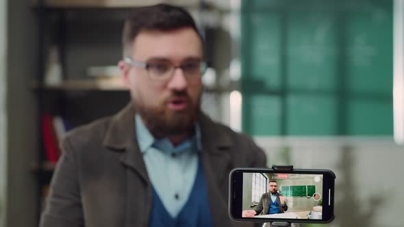 Young Man Teaches Online with a Smartphone in a School Class During Quarantine