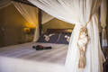 Luxury accommodation hotel bedroom details of a four poster bed and flowers laid up ready for guests - PhotoDune Item for Sale