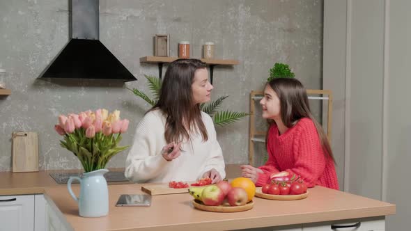 Mother Talks to Her Daughter While She Prepares the Vegetable Salad