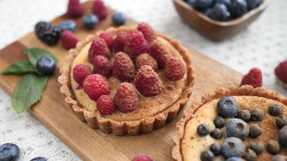 Berry Tartlets With Raspberry And Blueberry On Wooden Board.