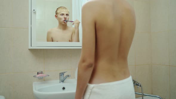 Handsome Man Brush Teeth Looking Face In Front Of Mirror. Sexy Man At Bathroom.