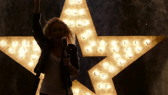 Sexy Blonde, Woman Singer with Microphone, Shining Star in the Background, Slow Motion, Silhouette
