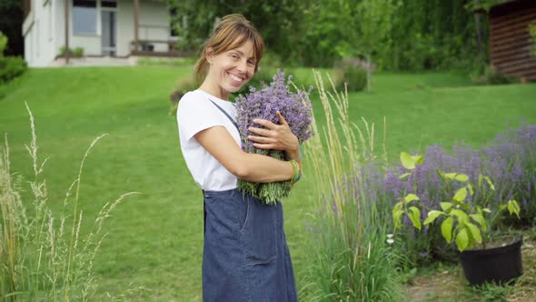 Live Camera Zoom in to Smiling Happy Gardener Posing with Bouquet of Lavender Outdoors