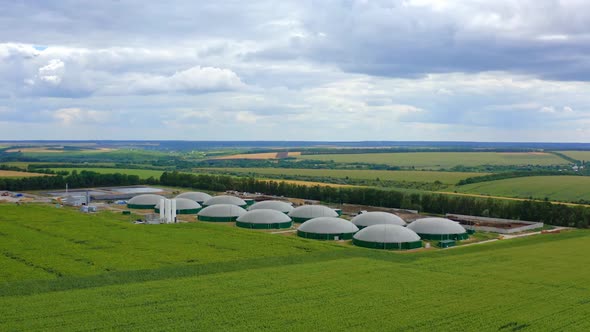 Agricultural farm for bio production. Biogas plant on green nature background.