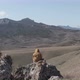 Man Sitting on a Stone on a Hillside Filming Drone - VideoHive Item for Sale