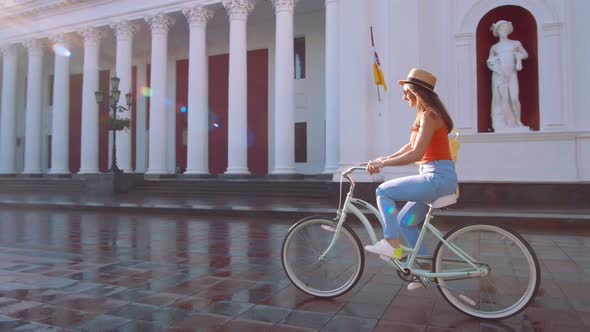 Young Attractive Woman in Hat Riding on Vintage Bike in City Center and Having Some Fun