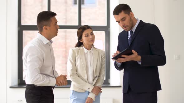 Realtor Showing Tablet Pc To Customers at Office 11