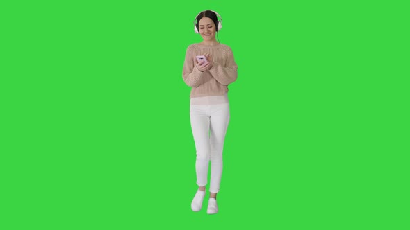 Beautiful Woman Having a Walk While Listening To Music on a Green Screen, Chroma Key