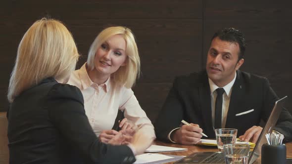 Three Business Partners Discuss Their New Working Project