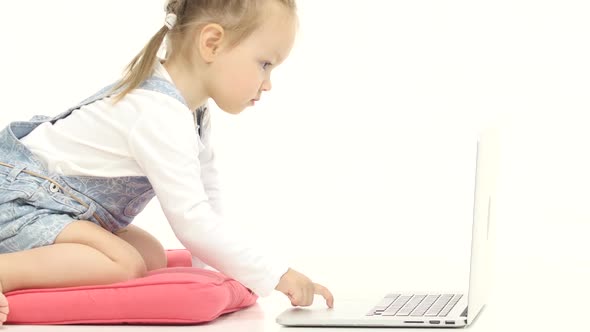 Little Girl Types the Text on the Keyboard. White Background. Close Up