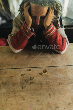 ith a few Euro coins on desk in front of him. Conceptual image of personal poverty and crisis.