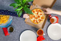 Small pizza pepperrone in a box on a set table, top view, family lunch. - PhotoDune Item for Sale