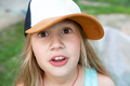 A surprised girl in a baseball cap is looking at the camera. - PhotoDune Item for Sale