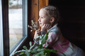 Beautiful girl looks out the window with a smile. - PhotoDune Item for Sale