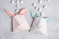Two bag of sweets in shape of Easter bunny with blue and pink ears on light gray - PhotoDune Item for Sale