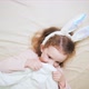 Top View a Baby Bed with a Cute Longhaired Baby Girl Under a White Blanket - VideoHive Item for Sale