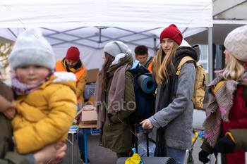 Ukrainian immigrants crossing border and getting donations from volunteers, Ukrainian war concept